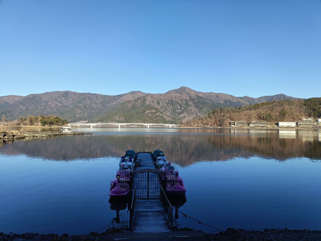 Lake Kawaguchiko with swan boats and serene mountain reflection